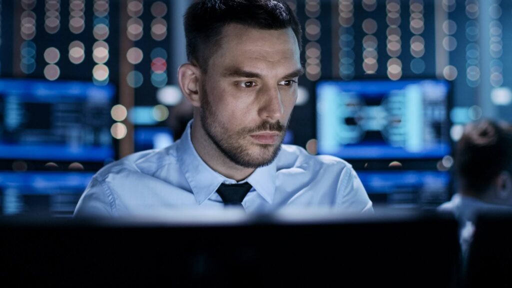 A cybersecurity professional in a computing center looks at a computer screen.